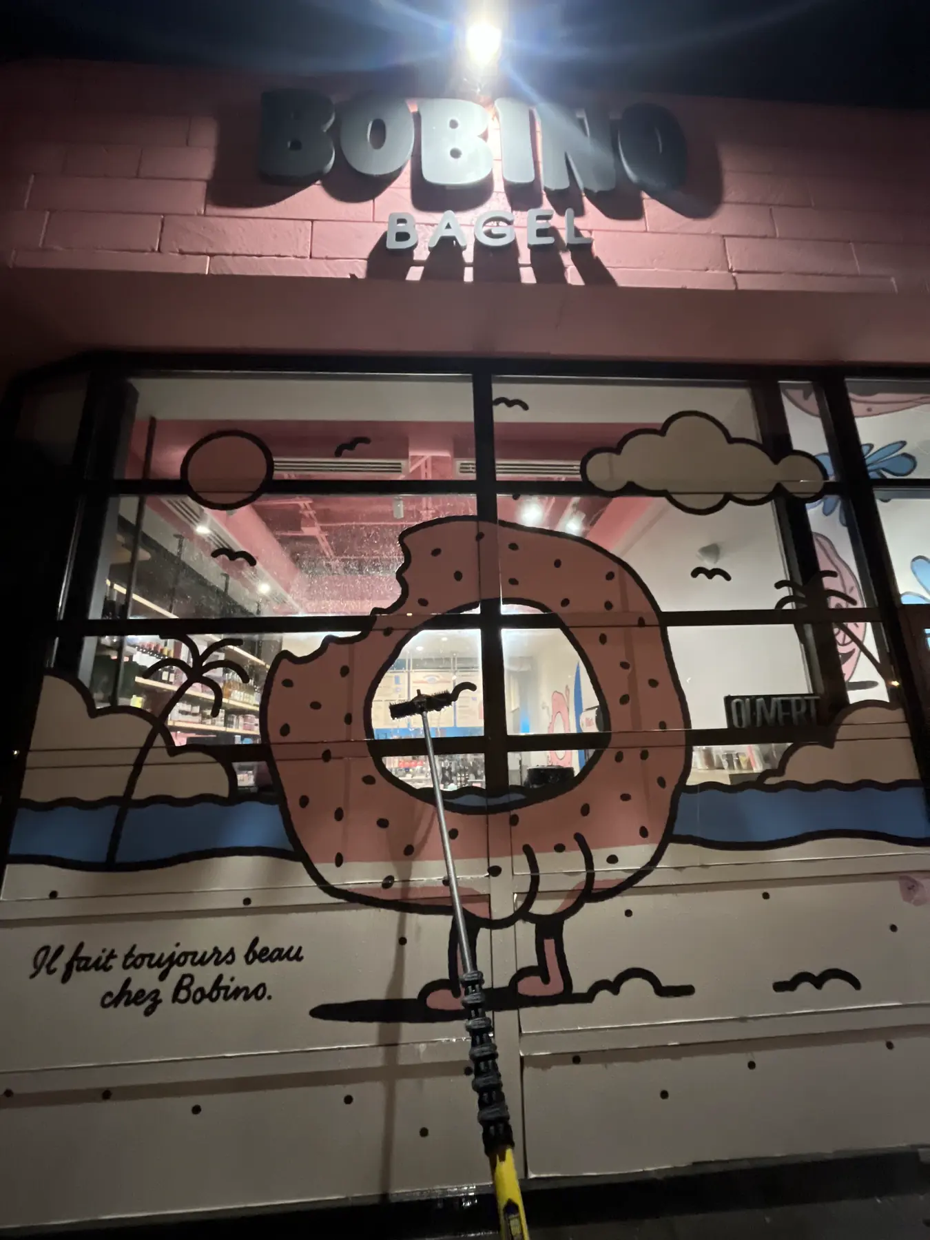 Vitrine de commerce nettoyée le soir à l'aide d'une perche à eau pure