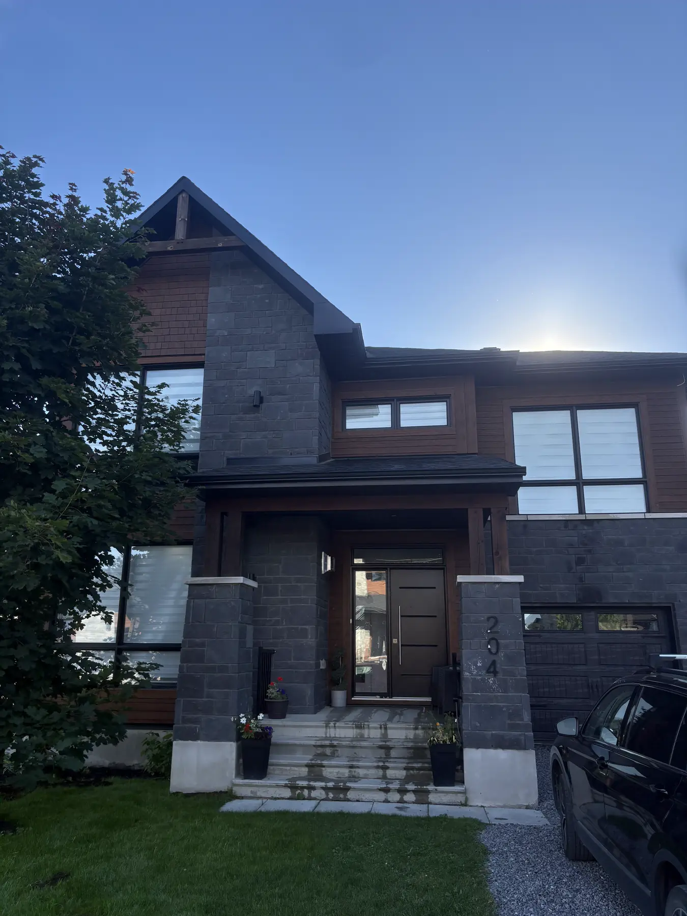 Marches et allée de pavés encore humides devant une maison en pierre et bois