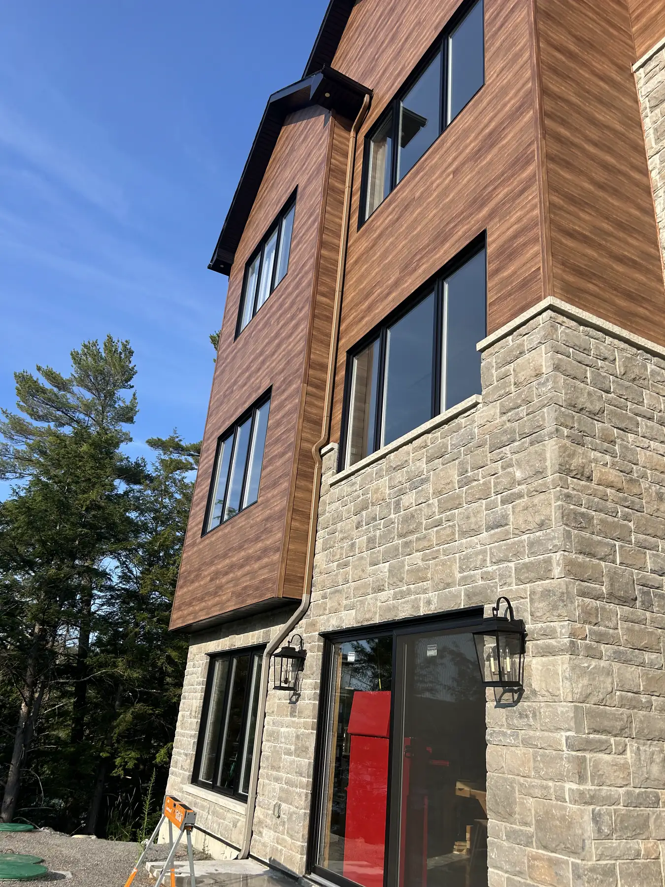 Descente de gouttière courant sur les trois étages d'une maison en bois et pierre